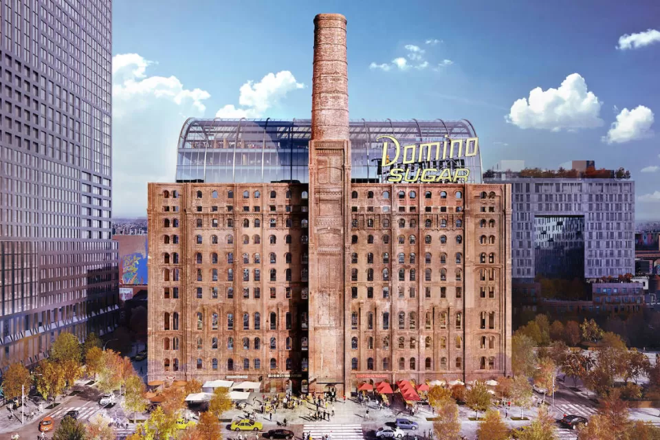 Historic brick sugar refinery building redeveloped with glass office tower inside and yellow Domino Sugar sign